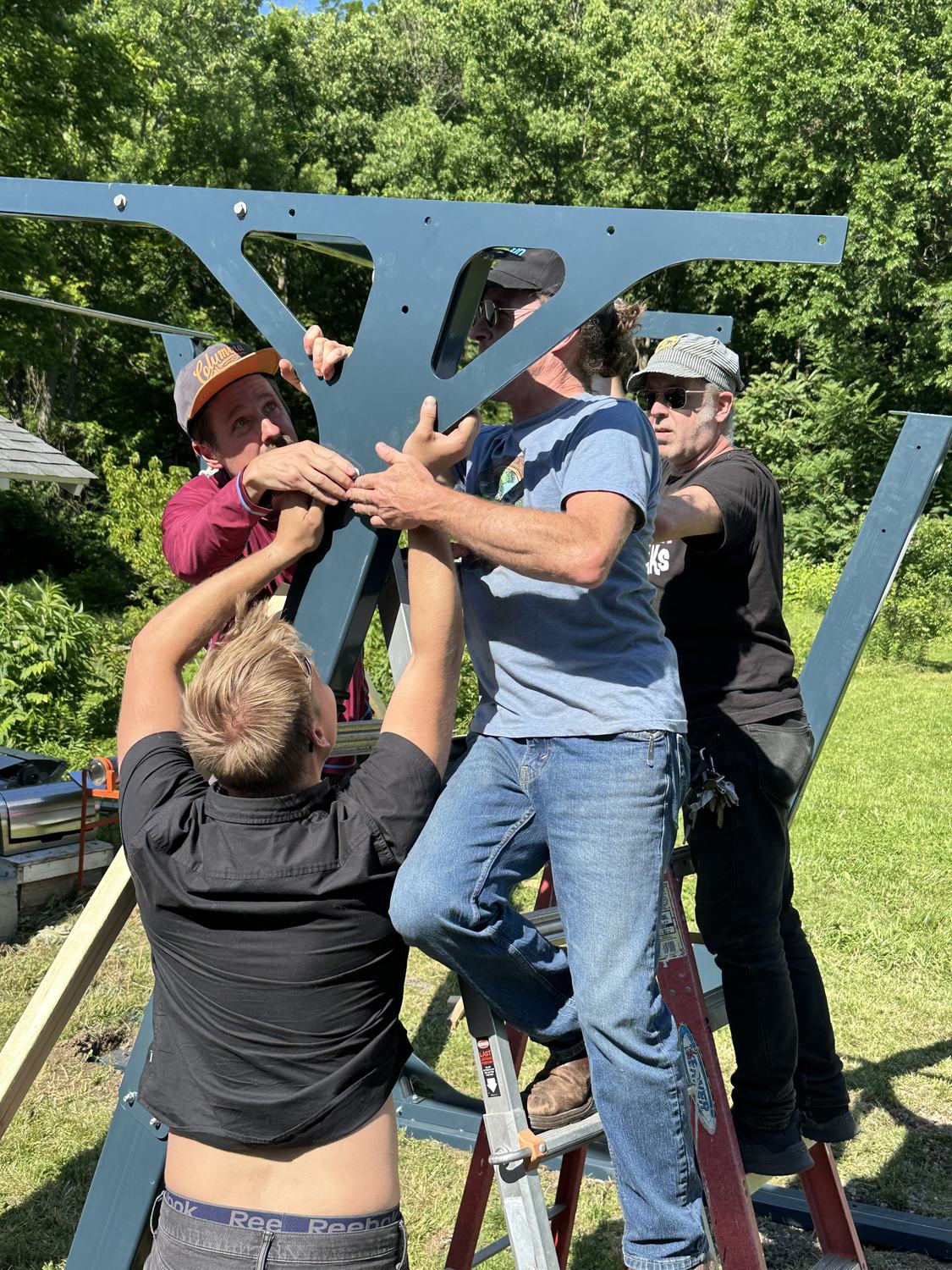 Crew raising the steel carport frame